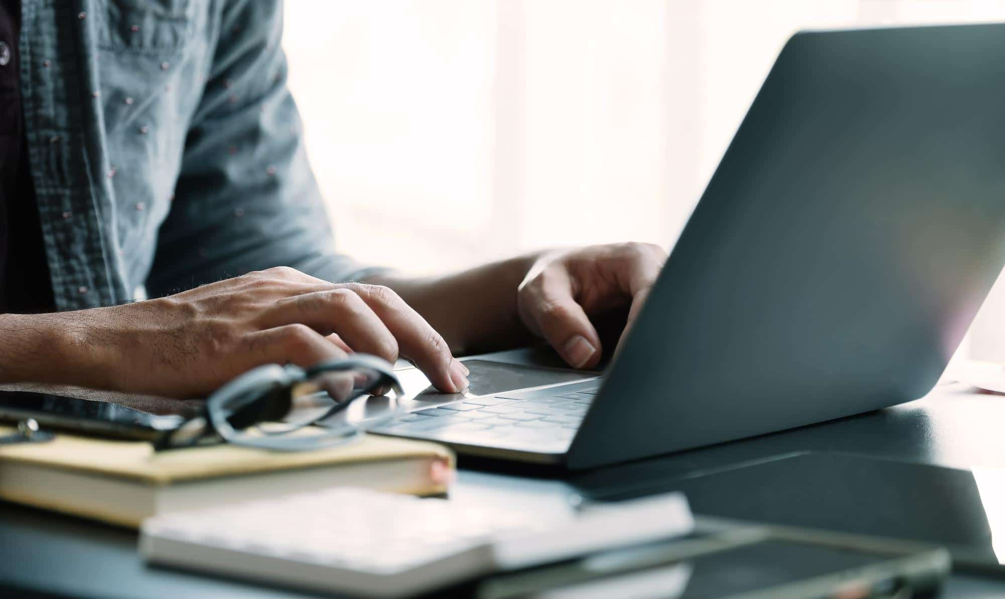 An expert medical transcriptionist using his laptop to transcribe medical records
