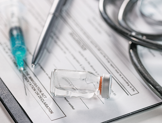 Syringe, medicine vial, and stethoscope on a clinical form